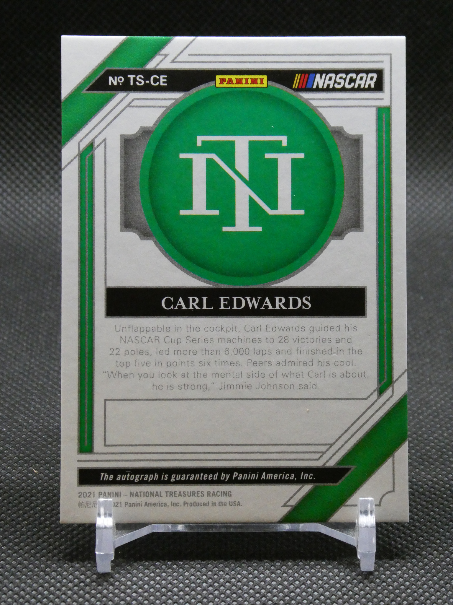 Carl Edwards trading card back featuring Panini and NASCAR logos with a green circular emblem and bio text on a silver/green design.