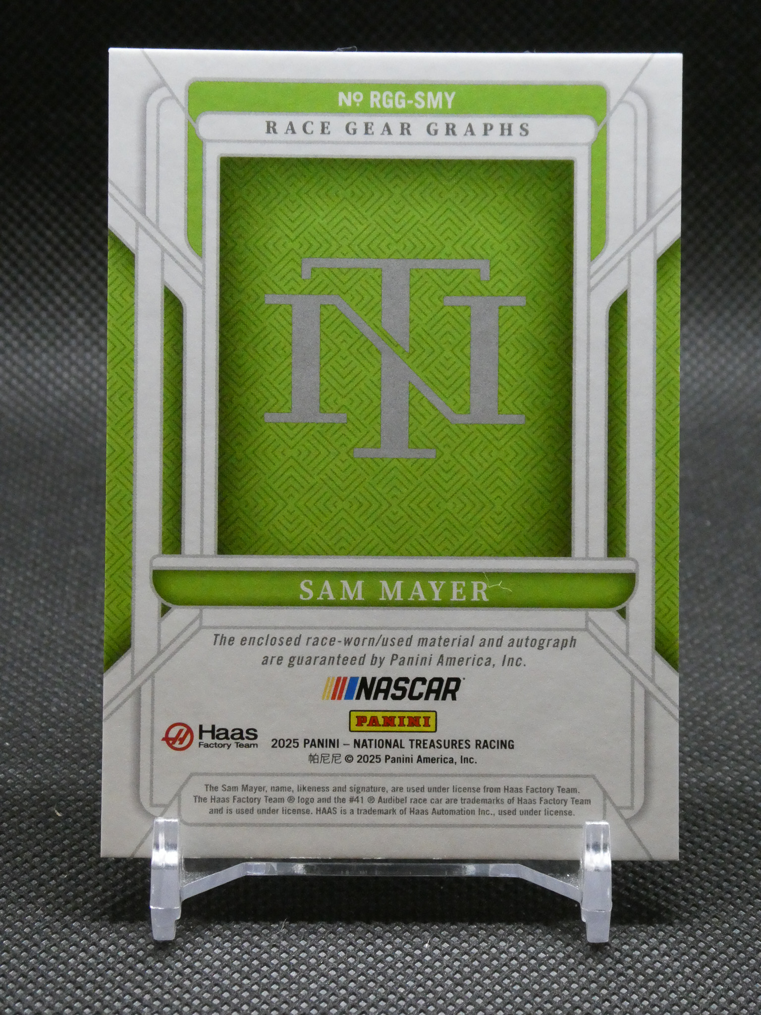 Front of a Sam Mayer NASCAR Panini trading card featuring a large green design and TNT logo with text 'Sam Mayer' at the bottom center.