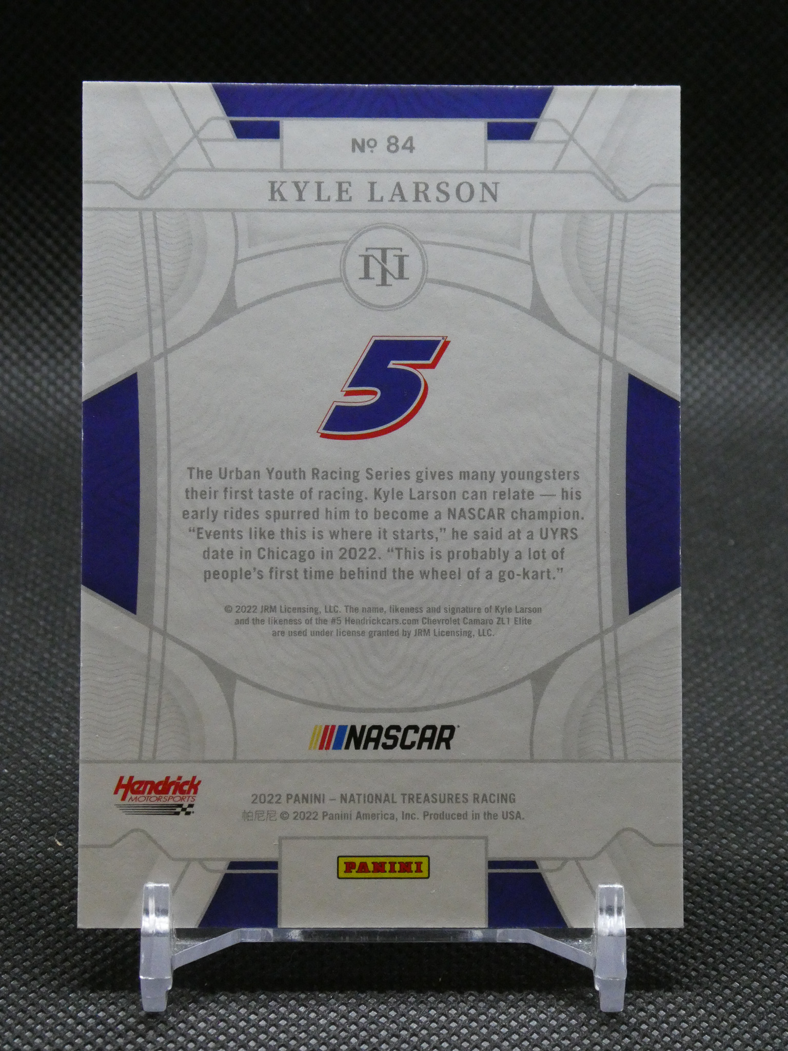 Back of a Panini NASCAR trading card for Kyle Larson (No. 84) featuring a large blue 5, NASCAR and Panini logos, with descriptive text in the middle.