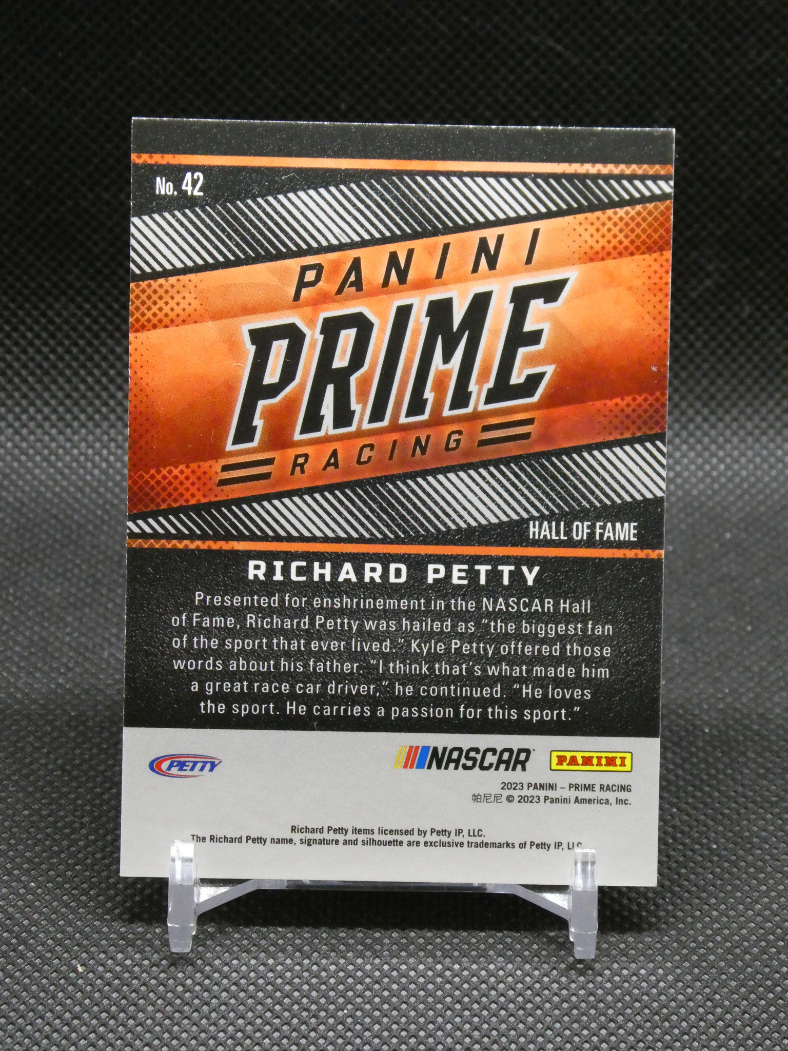 Panini Prime Racing trading card featuring Richard Petty with Hall of Fame banner and descriptive text on a black background display stand.