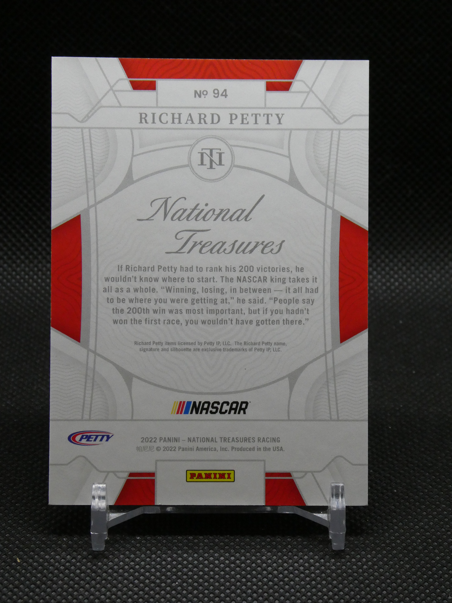 Front of a Panini NASCAR National Treasures card featuring Richard Petty No. 94 with NASCAR and Panini logos on a grayscale design with red accents.
