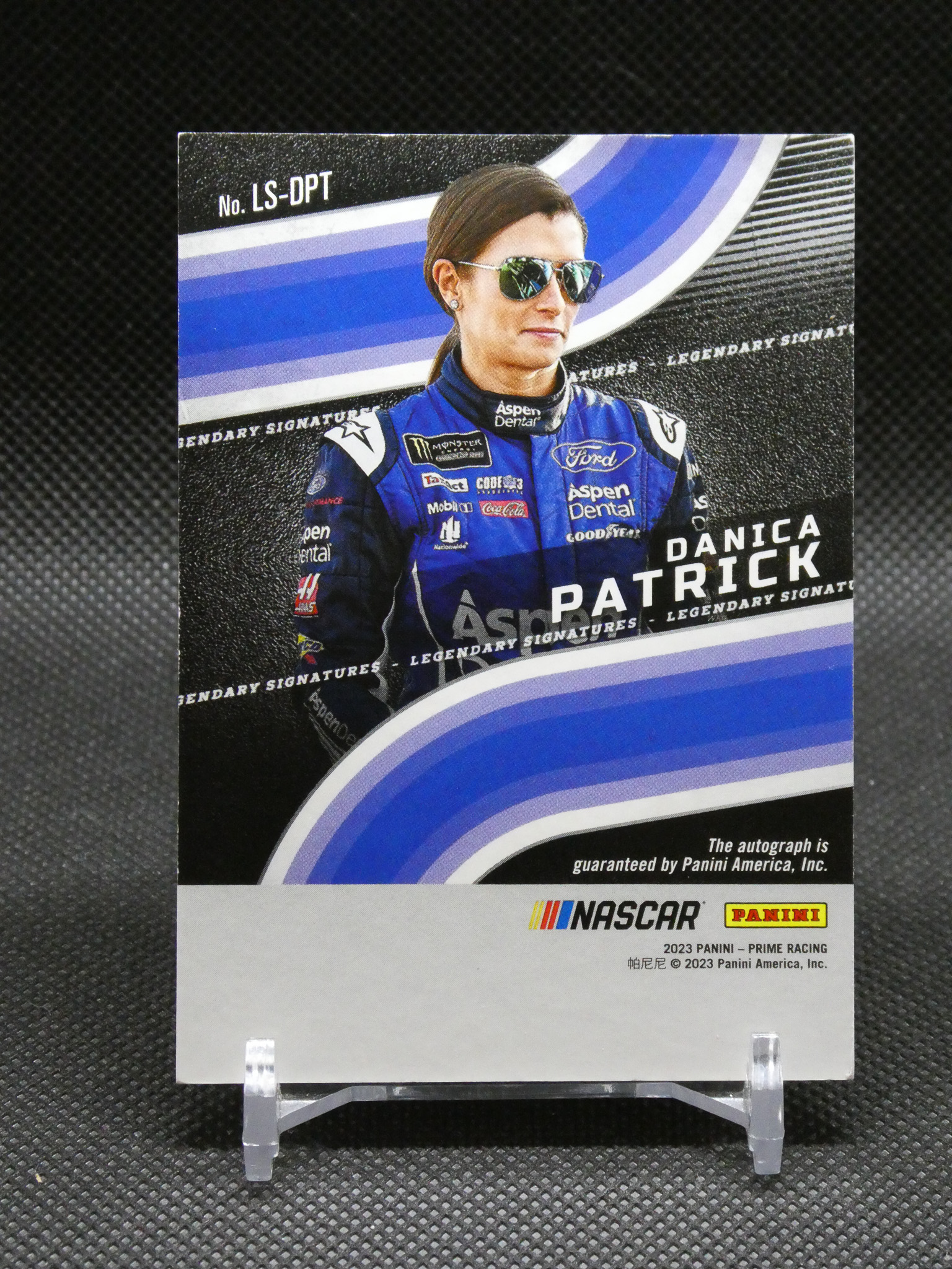 Trading card of NASCAR driver Danica Patrick in a blue racing suit, wearing sunglasses.