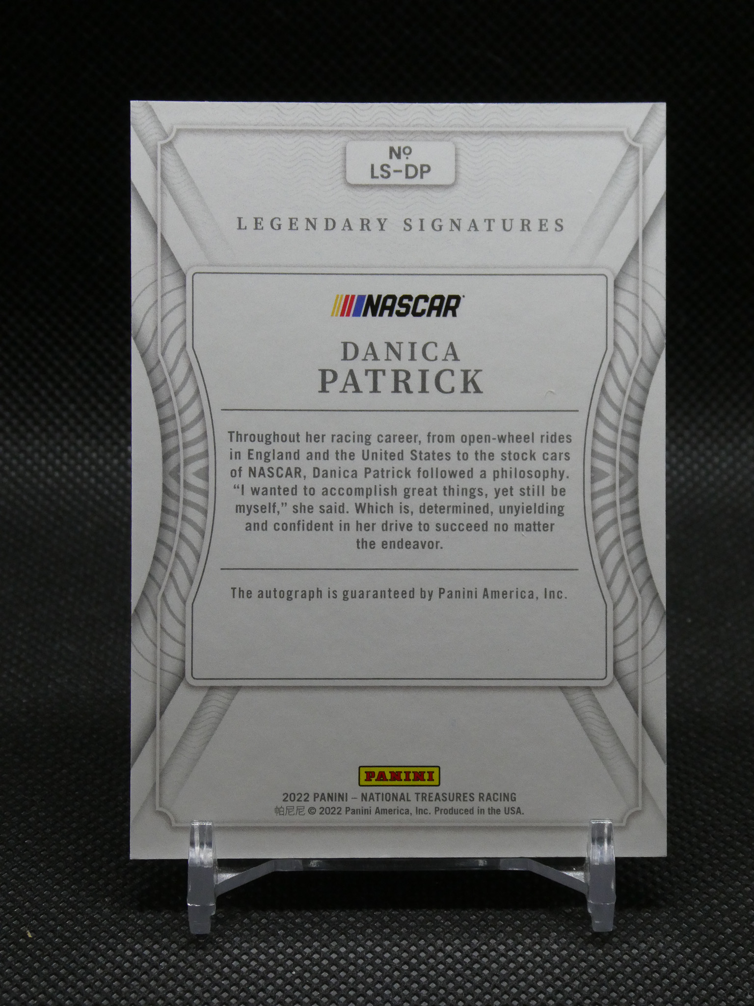 Panini NASCAR Legendary Signatures card featuring Danica Patrick, displayed on a stand against a dark background.