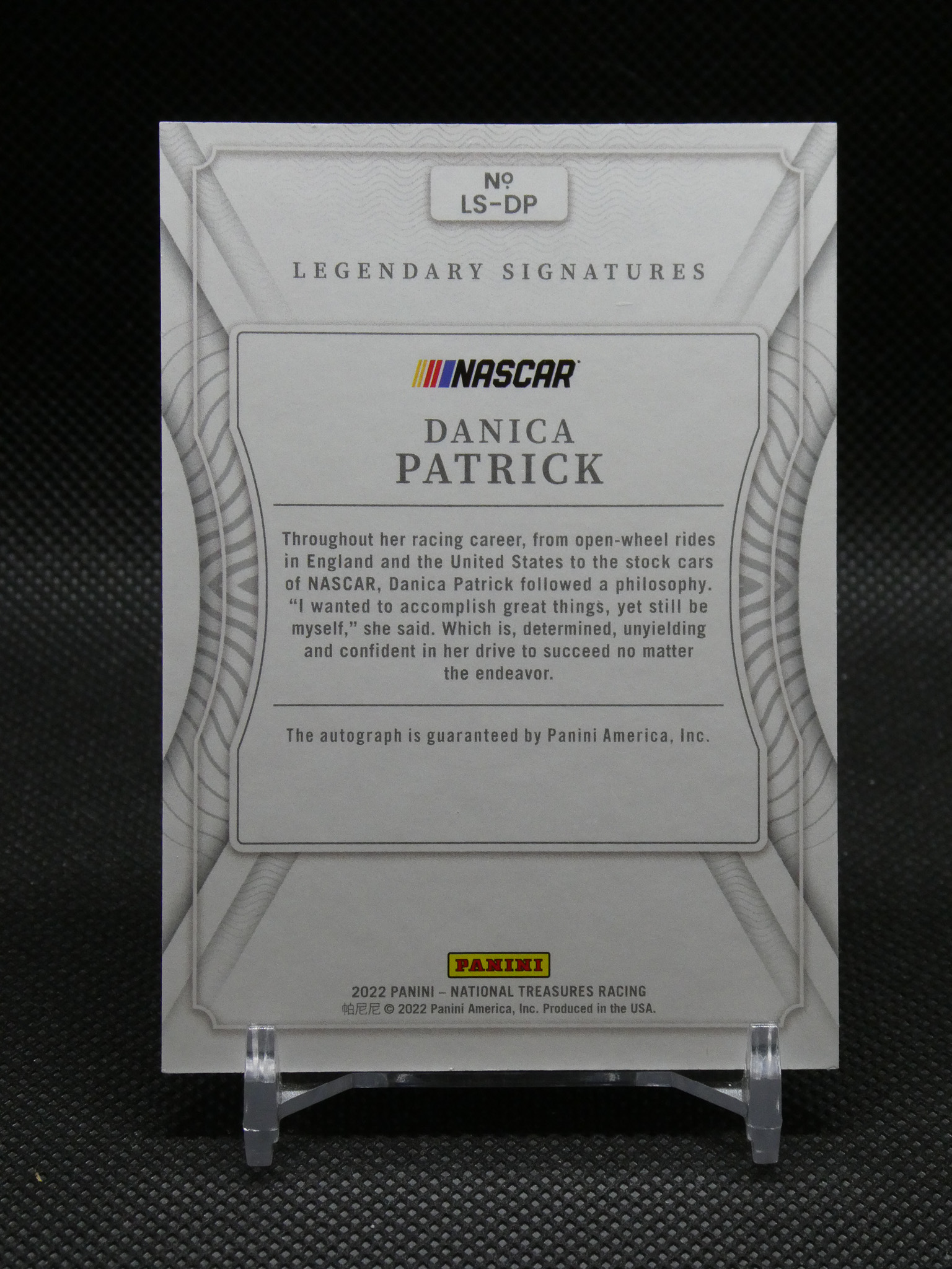 Back of a Panini NASCAR Legendary Signatures trading card featuring Danica Patrick, with bio text and Panini logo framed in gray decorative borders.