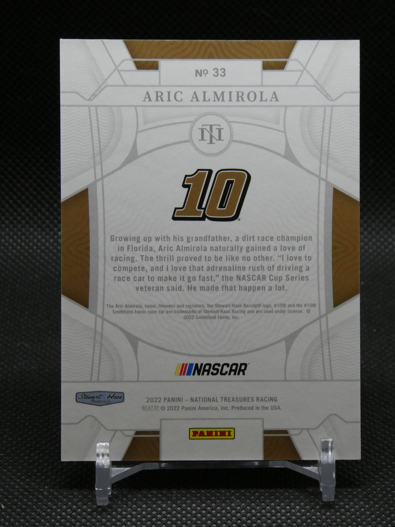 Panini NASCAR card featuring Aric Almirola (No. 33) with a large gold '10' and grey geometric design.
