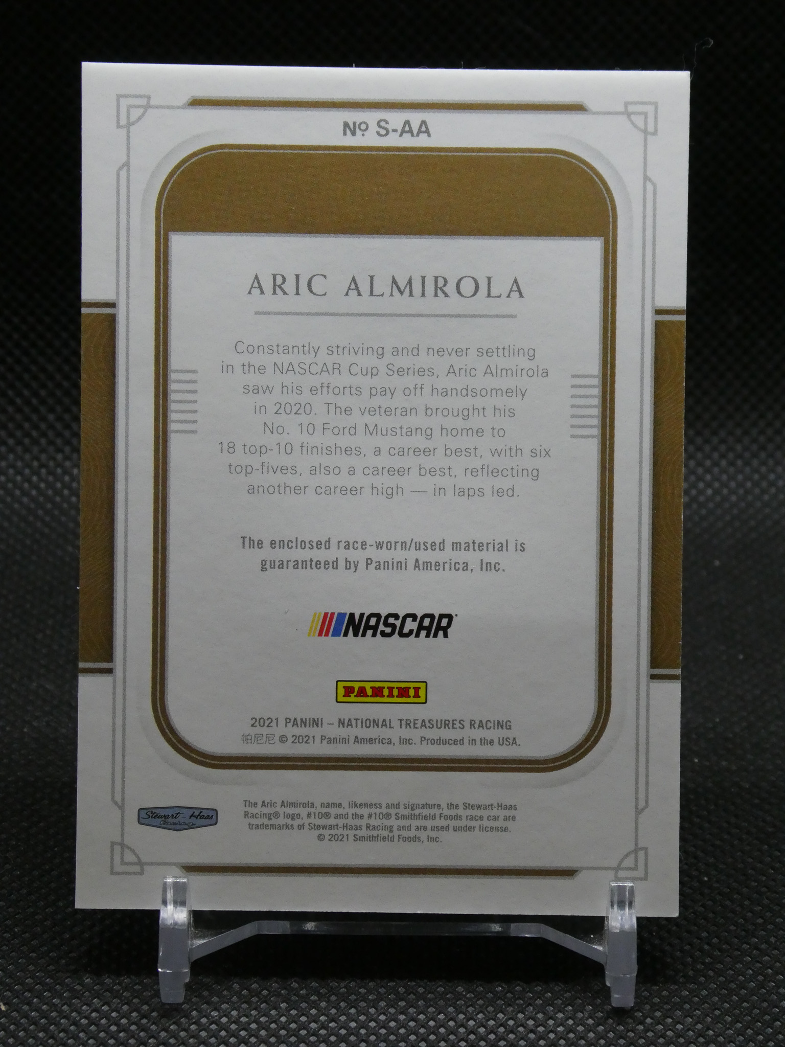 Card back featuring Aric Almirola from Panini NASCAR racing collection, with readable biography text and NASCAR/PANINI logos.