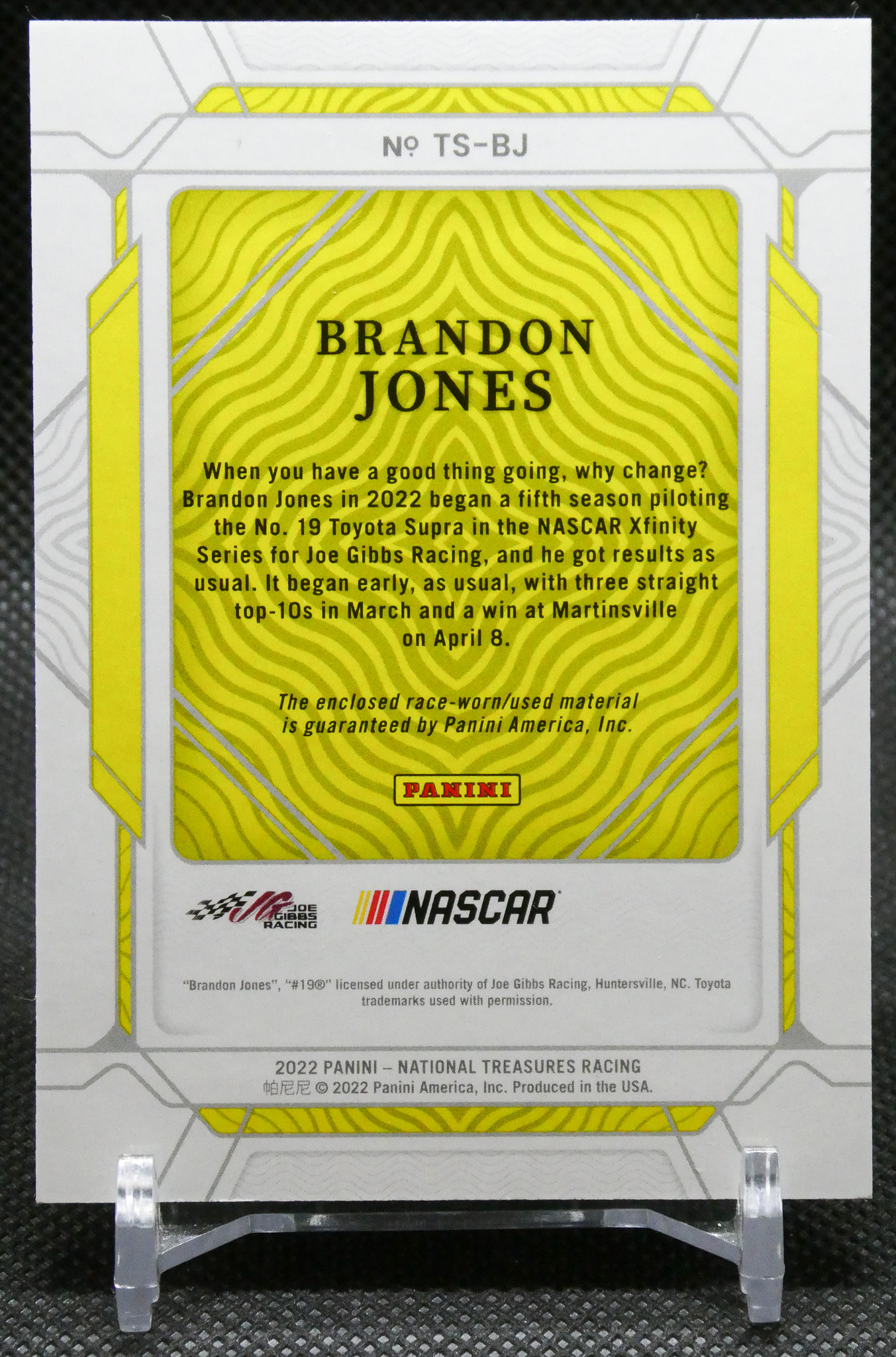 Back of a Panini NASCAR trading card for Brandon Jones, featuring a bright yellow wavy pattern and a block of descriptive text.