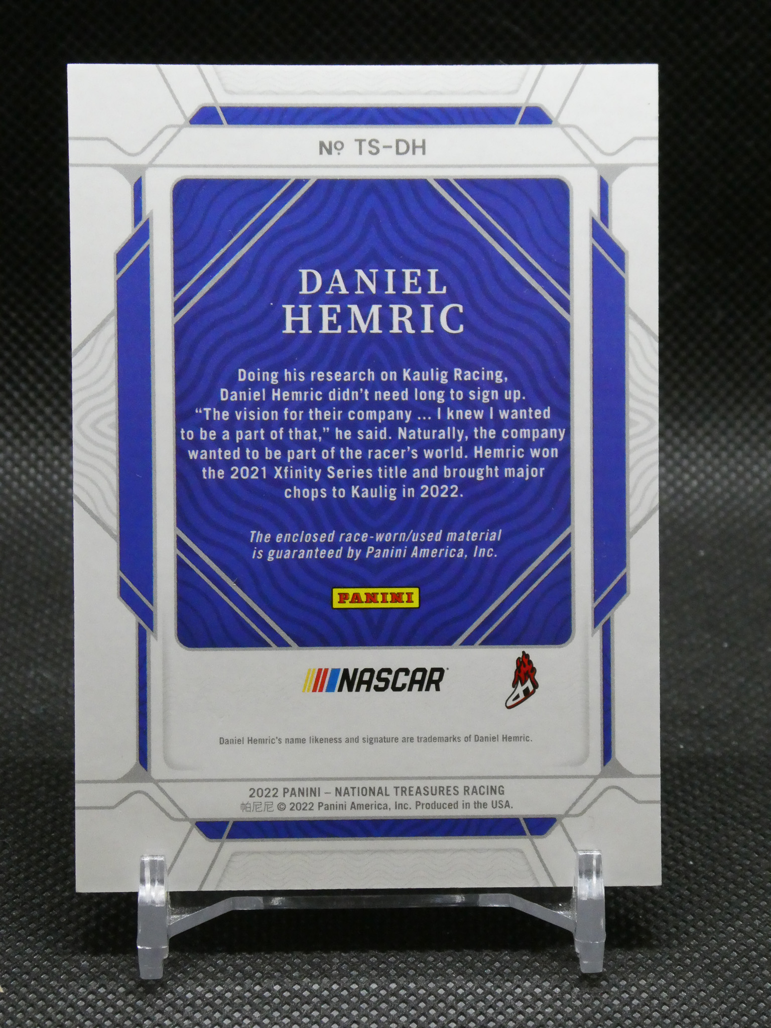 Back of a Panini NASCAR trading card featuring Daniel Hemric on a blue wavy card with Panini logo and formal description text.