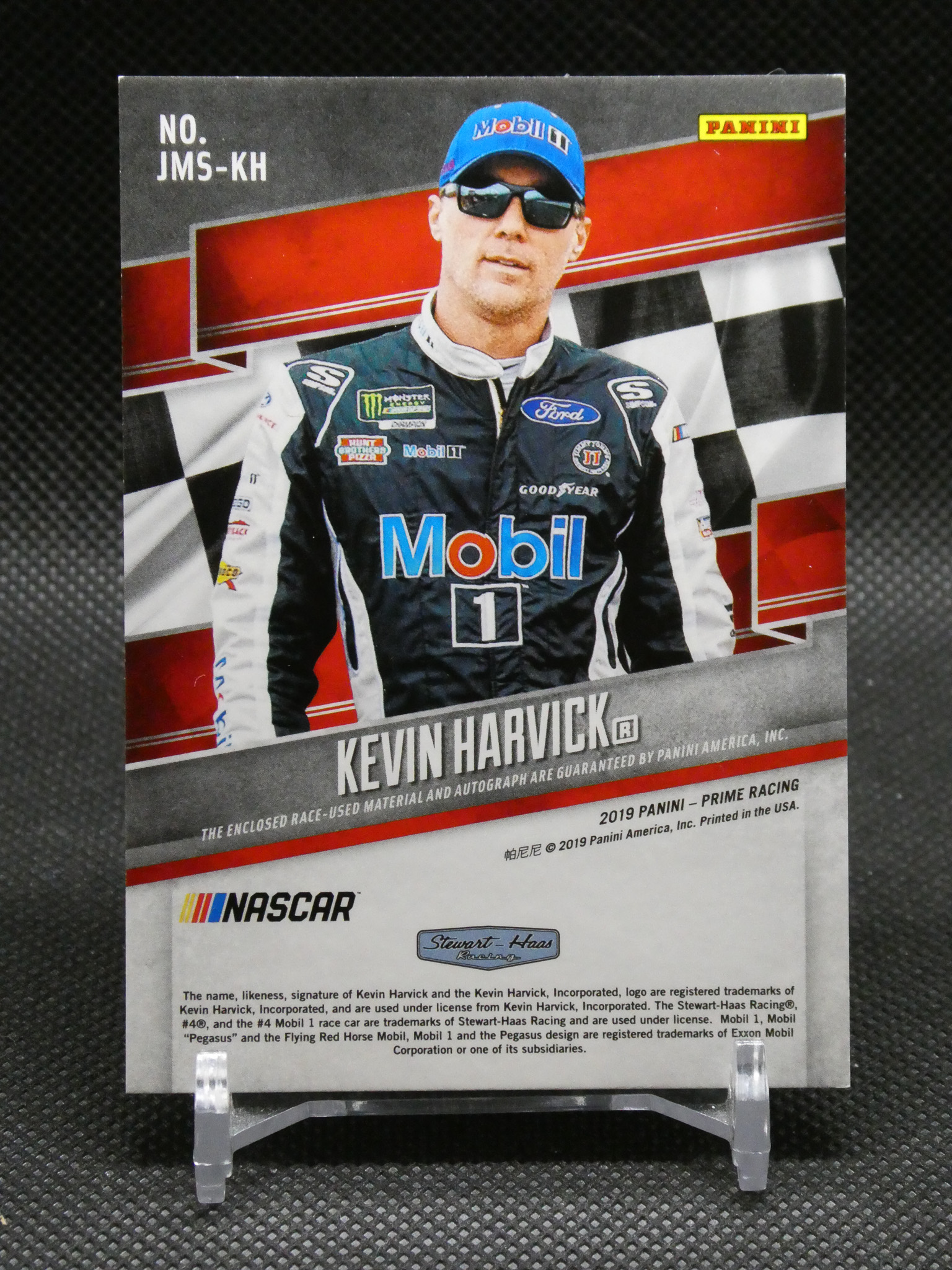 Panini NASCAR trading card featuring driver Kevin Harvick in a Mobil 1 racing suit with checkered background and sponsor logos, 2019 Prime Racing edition