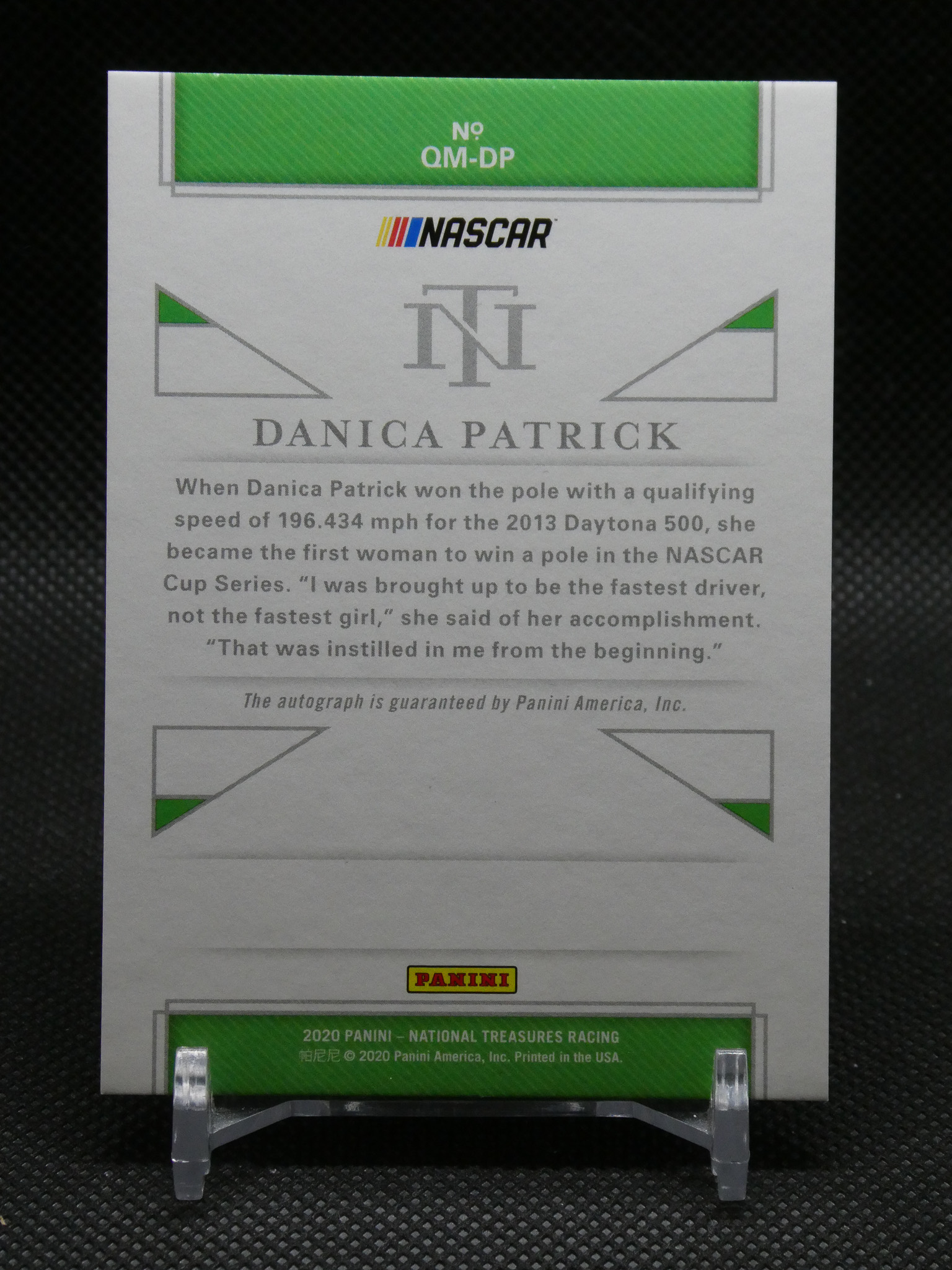 Back of a Panini NASCAR trading card for Danica Patrick, showing No. QM-DP, NASCAR logo, large DANICA PATRICK text, and descriptive bio paragraph.