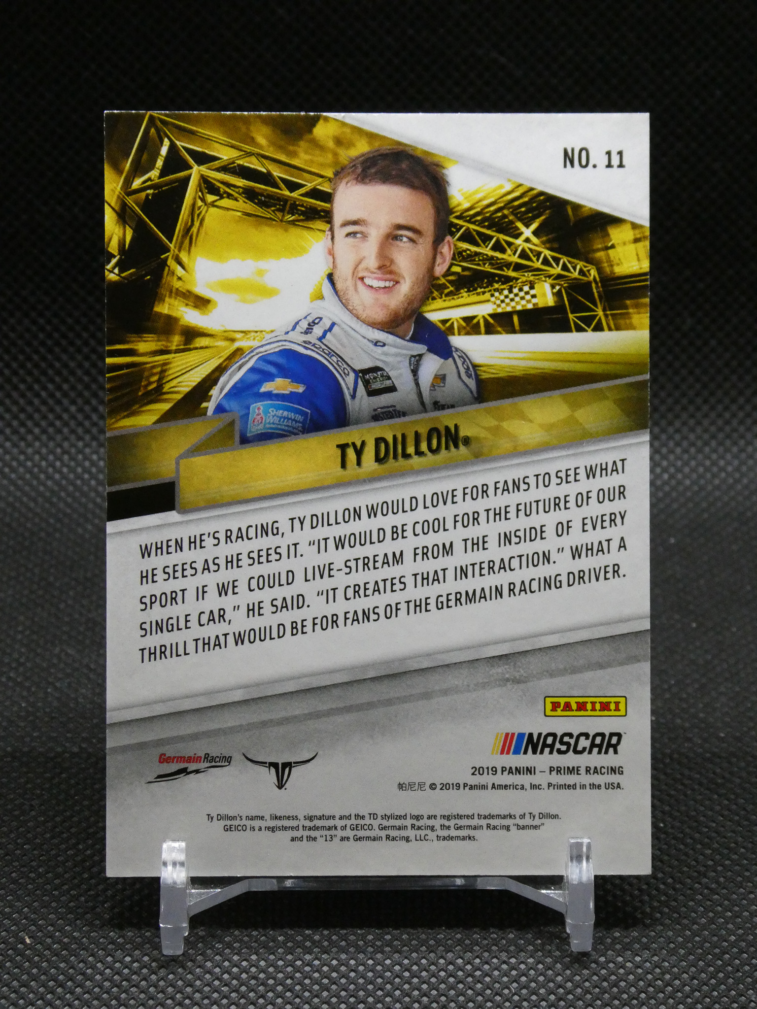 Panini NASCAR trading card featuring Ty Dillon in a blue racing suit, with TY DILLON text and a gold background.