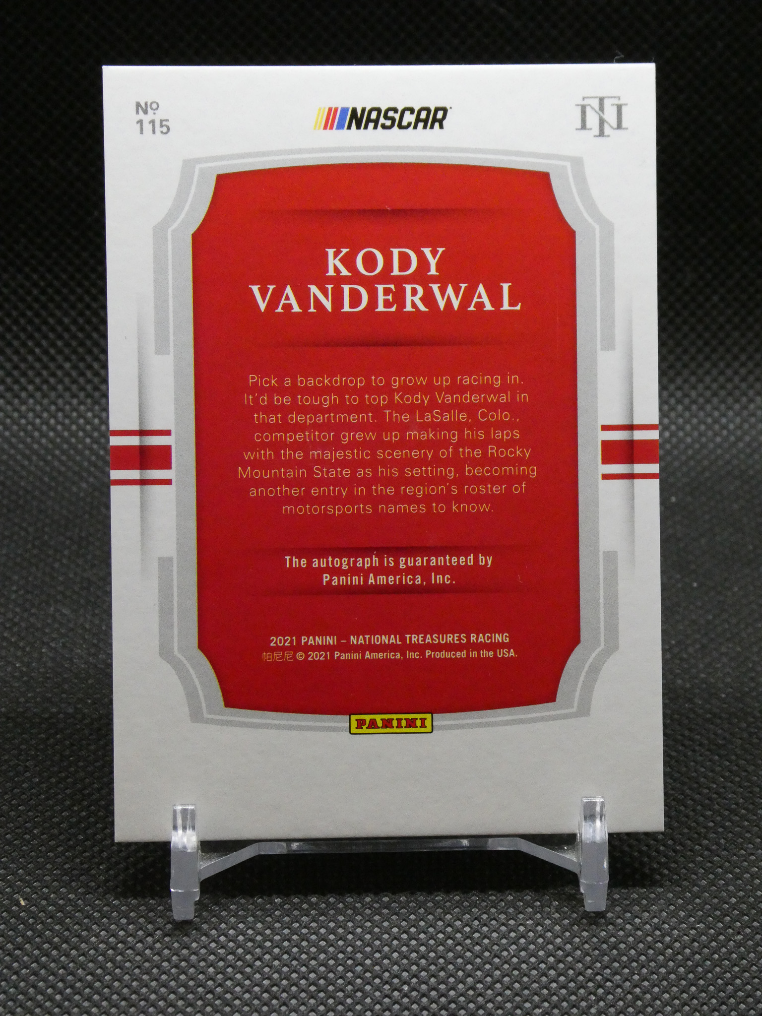 Front of a NASCAR Panini trading card for Kody Vanderwal, red center panel with biography text and Panini logo at bottom margin.