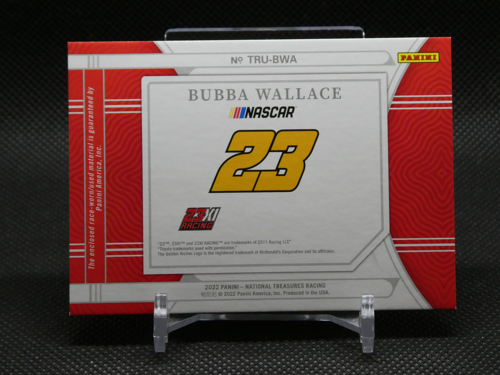 A Panini NASCAR Bubba Wallace trading card box with a large yellow 23 logo and 23XI Racing, red patterned sides, and Panini logo in the corner.