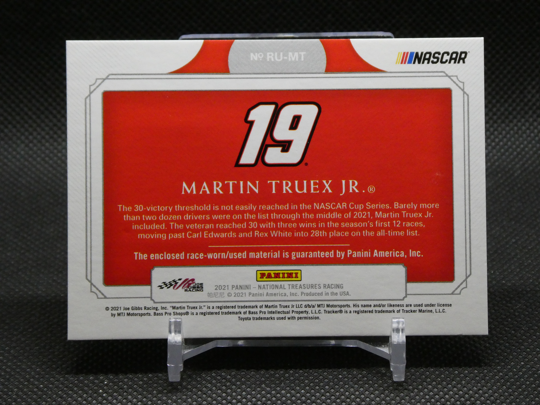 NASCAR Panini trading card featuring Martin Truex Jr., number 19, on a white display stand with a red center panel.