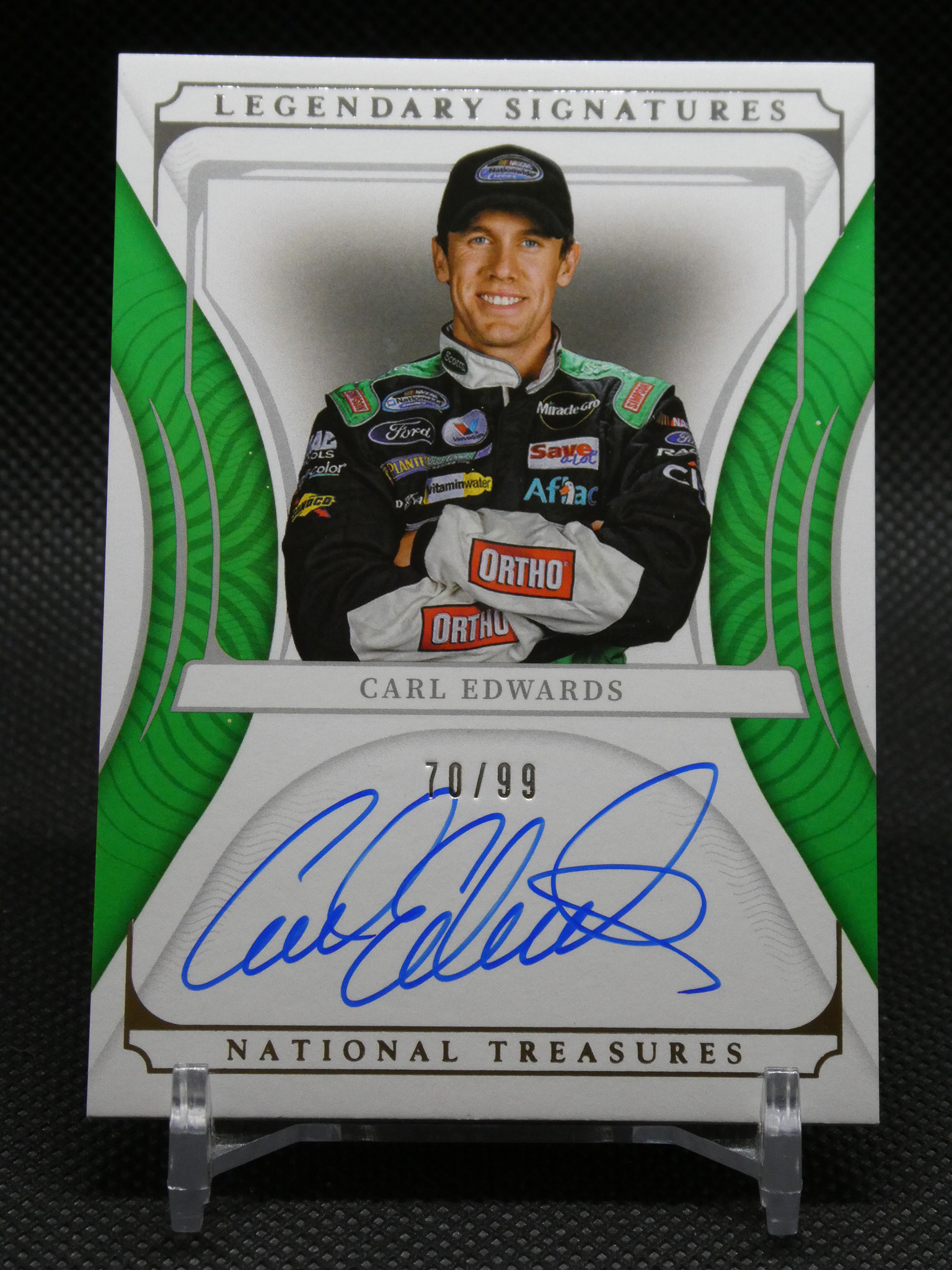 Autographed trading card featuring a race car driver in a green-and-black suit with sponsor logos.