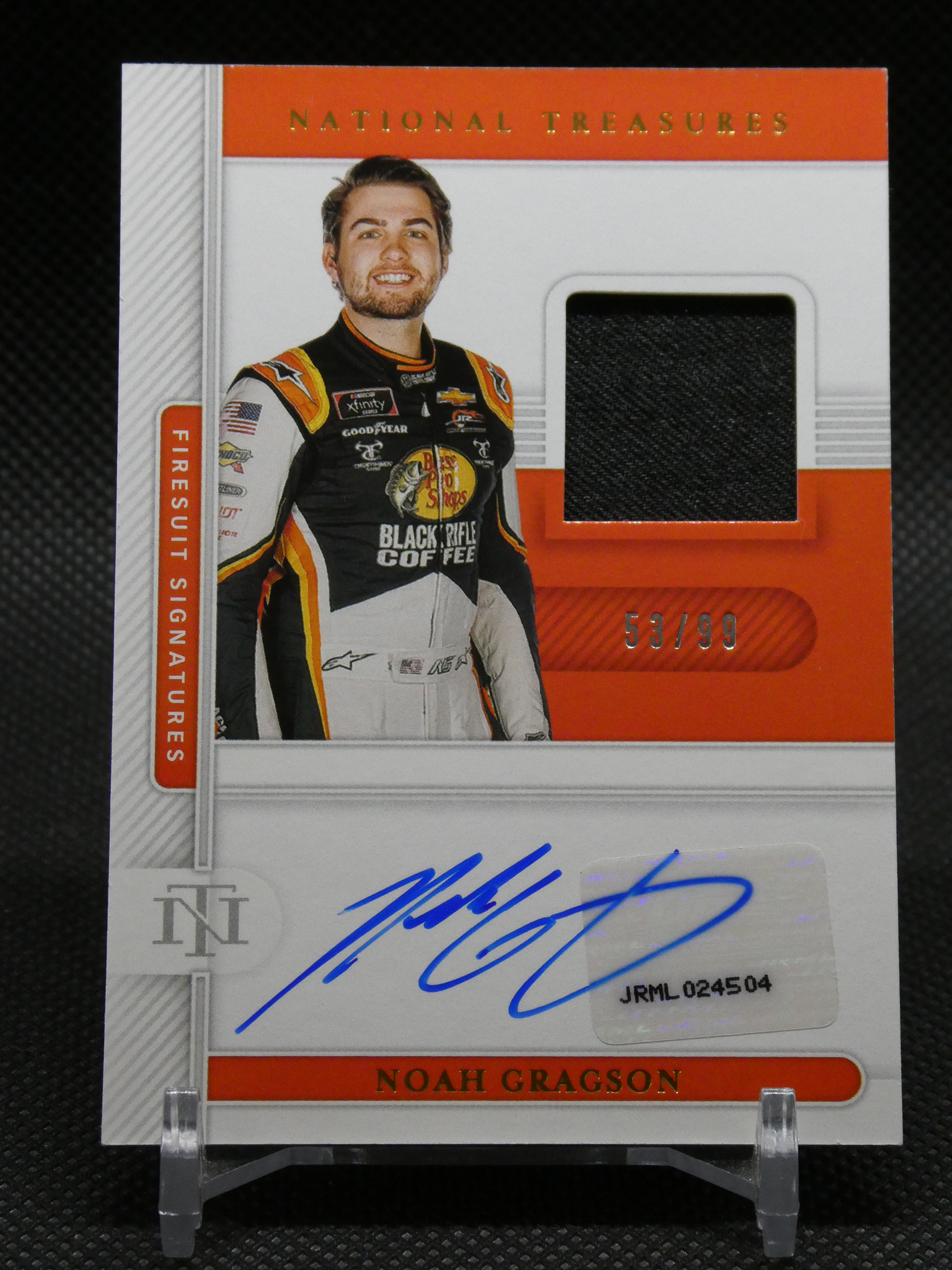Noah Gragson autographed National Treasures trading card showing him in an orange-black racing suit with a blue signature and 53/99.