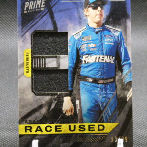 Panini Prime Racing collectible card showing a driver in a blue racing suit with a fabric swatch and a bold 'RACE USED' banner at the bottom.