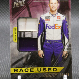 Panini Prime Racing trading card featuring NASCAR driver Denny Hamlin, with a small metal swatch window and a bold 'RACE USED' banner at the bottom.