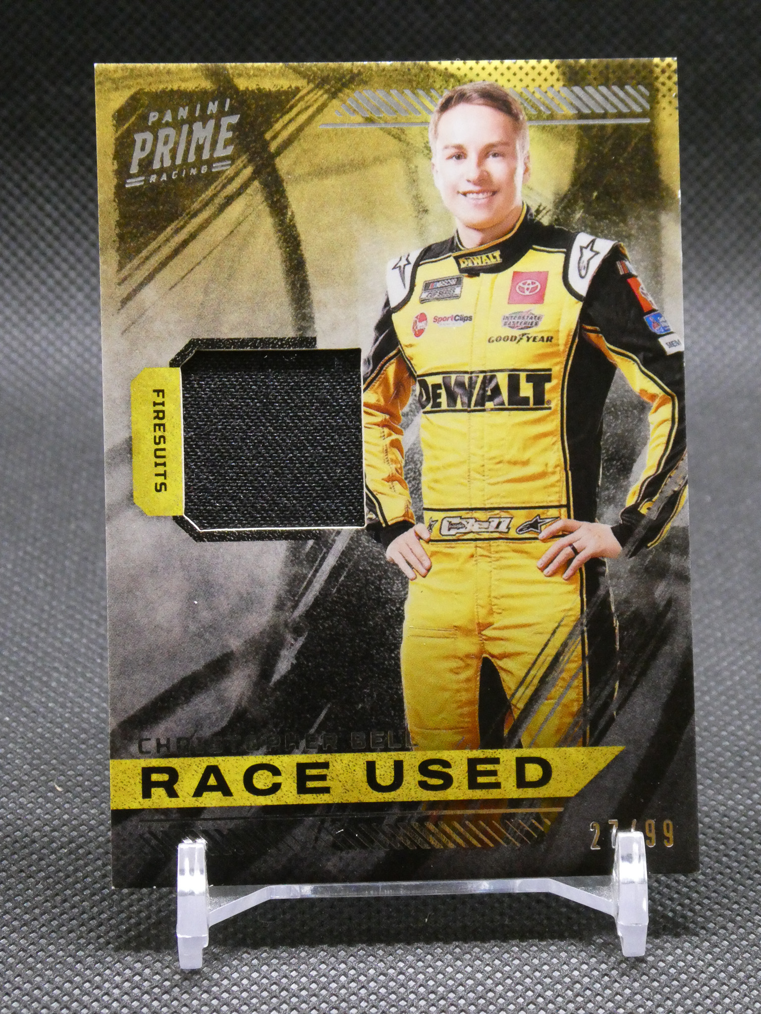 Trading card featuring a race car driver in a yellow DeWALT racing suit, with 'RACE USED' text at the bottom.