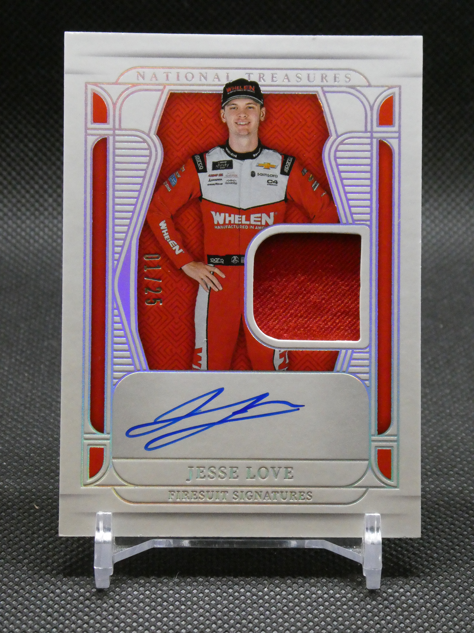 Autographed racing card showing driver Jesse Love in a red and white Whelen racing suit, with a blue signature on the lower panel and 'National Treasures' branding above.