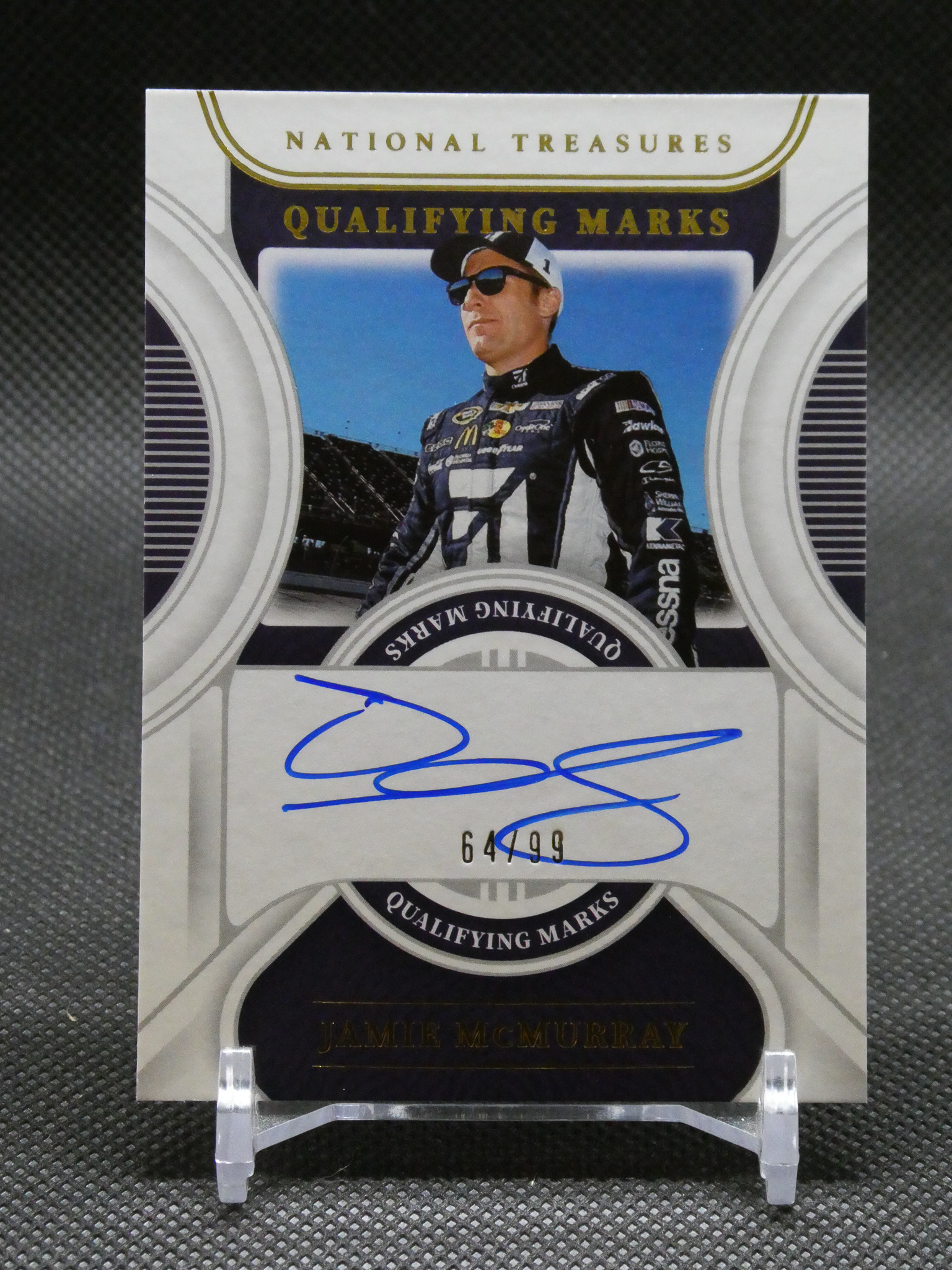 Autographed NASCAR trading card featuring Jamie McMurray in a racing suit, limited edition 64/99, with 'Qualifying Marks' design.