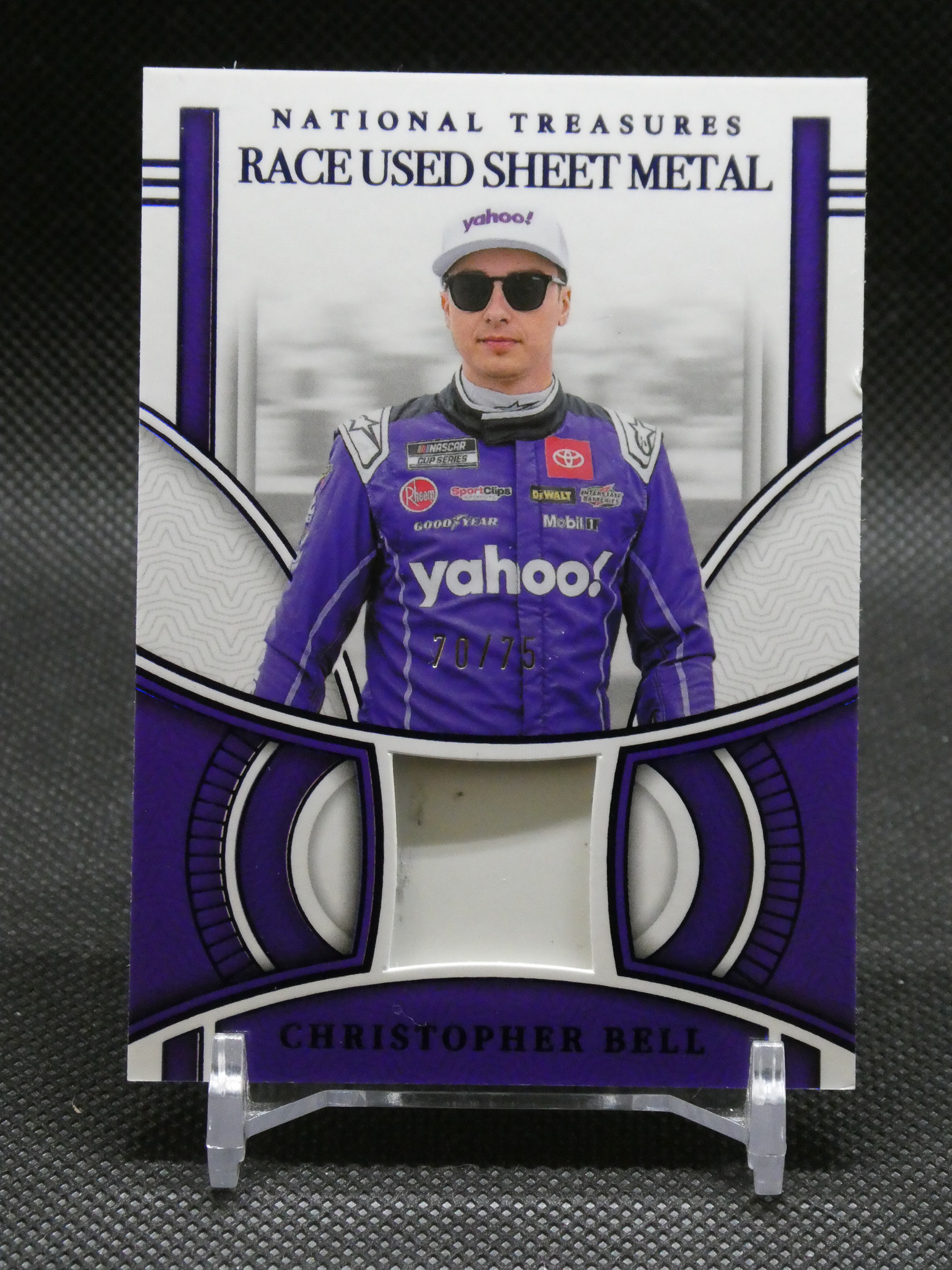 Widely spaced image of a NASCAR collector card featuring Christopher Bell in a purple racing suit with 'yahoo' on the cap and sunglasses, captioned 'RACE USED SHEET METAL' and 'CHRISTOPHER BELL' at the bottom.