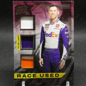 Racing memorabilia card showing a driver in a purple-white suit with race-used fabric swatches on the left and 'RACE USED' text at the bottom