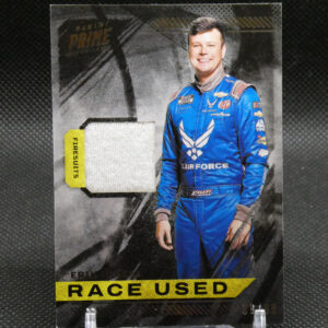 Promotional trading card showing a smiling race car driver in a blue suit, with a yellow 'RACE USED' banner at the bottom.