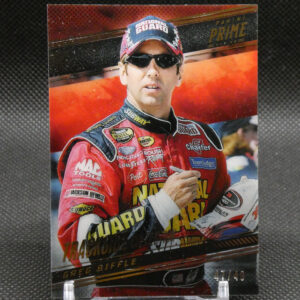 NASCAR driver portrait on a red racing suit, wearing sunglasses and a cap, displayed on a clear stand against a dark background.