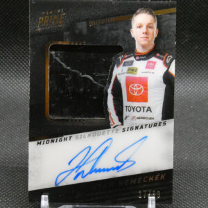 Autographed racing card featuring a driver in a white Toyota racing suit with team logos, mounted on a black backing and showing a blue signature at the bottom edge.