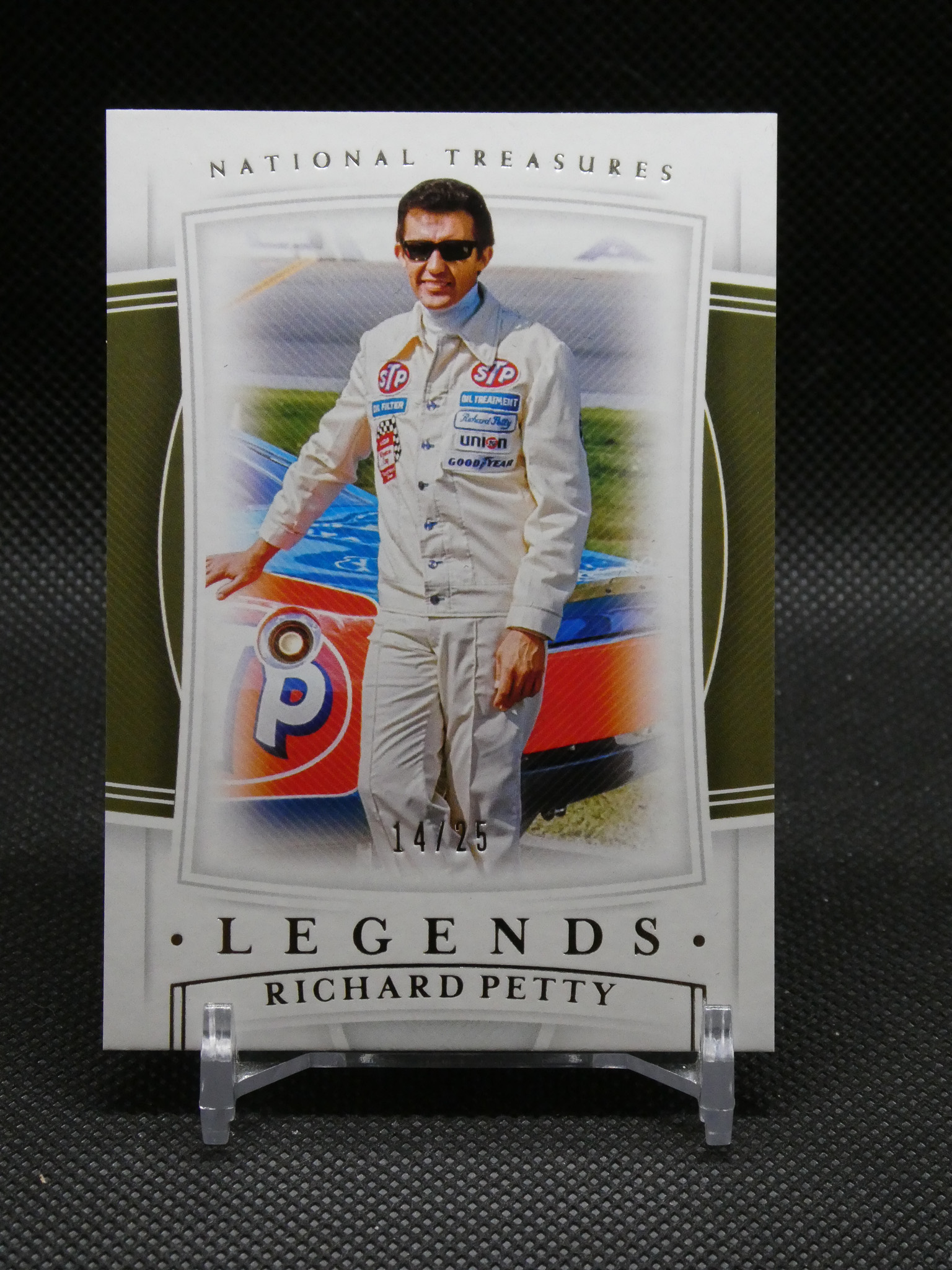 Poster of NASCAR driver Richard Petty in a white racing suit with sponsor patches beside a race car, 14/25 edition