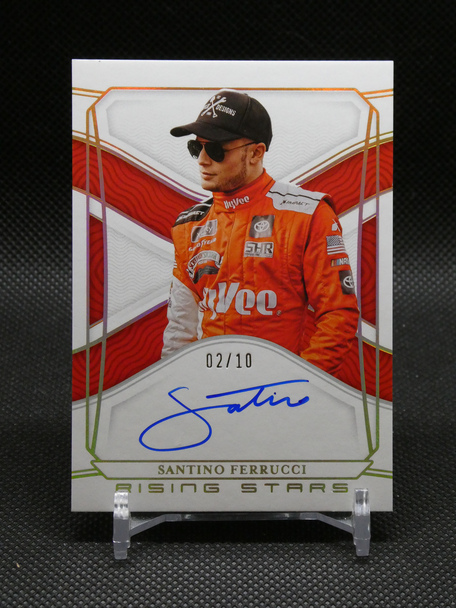 Trading card featuring driver Santino Ferrucci in an orange racing suit with signature visible on the card (limited 02/10).