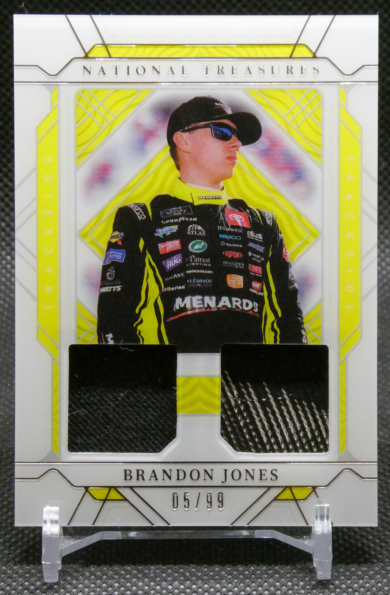 Card featuring Brandon Jones in a neon-yellow frame, wearing racing suit and sunglasses; text reads ' Brandon Jones' and '05/99' at bottom.