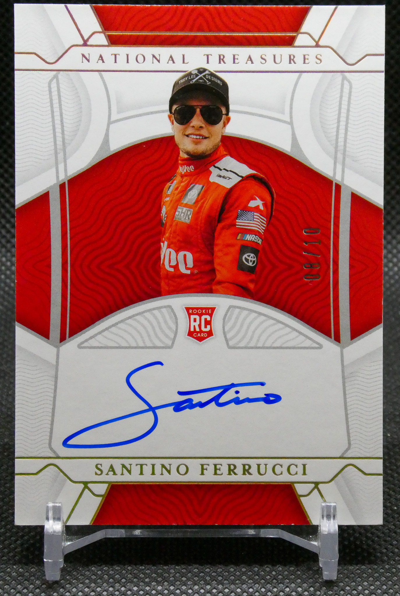 Autographed Santino Ferrucci rookie card featuring him in a red racing suit and sunglasses with a blue signature across the bottom panel.