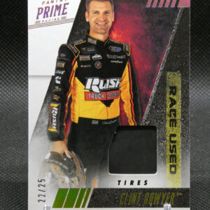 Trading card of NASCAR driver Clint Bowyer in a yellow-black racing suit, Panini Prime Racing logo top left, bold red/black background, smiling.