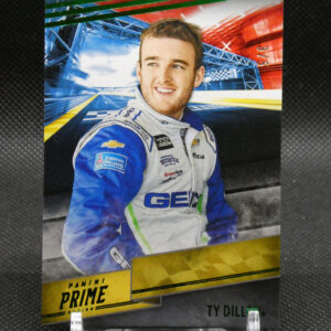 Portrait of a smiling race car driver in a blue and white suit on a glossy poster with Panini Prime branding in the foreground.