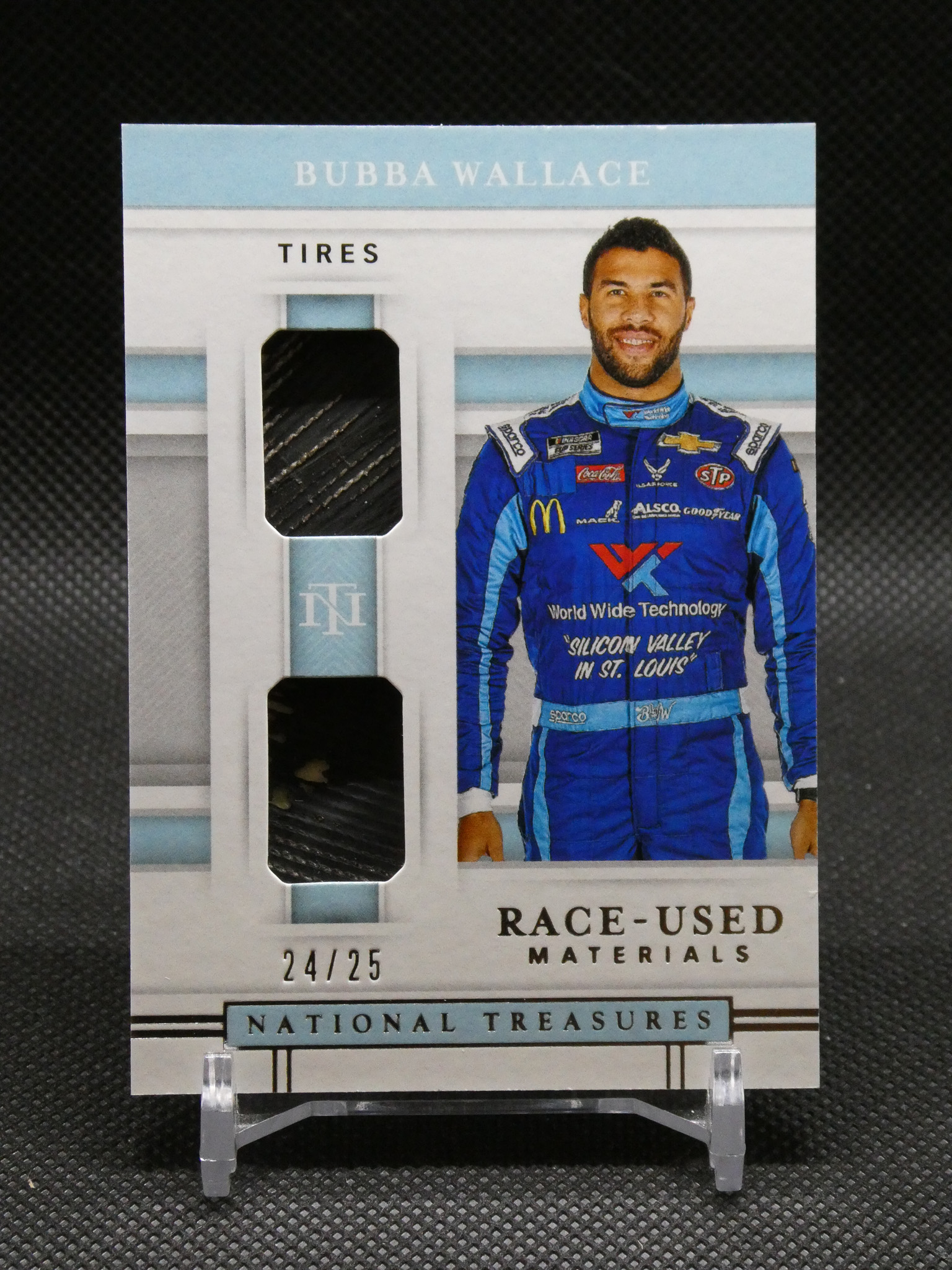 Cardboard display featuring Bubba Wallace in a blue racing suit standing beside a tire display labeled TIRES at the top.
