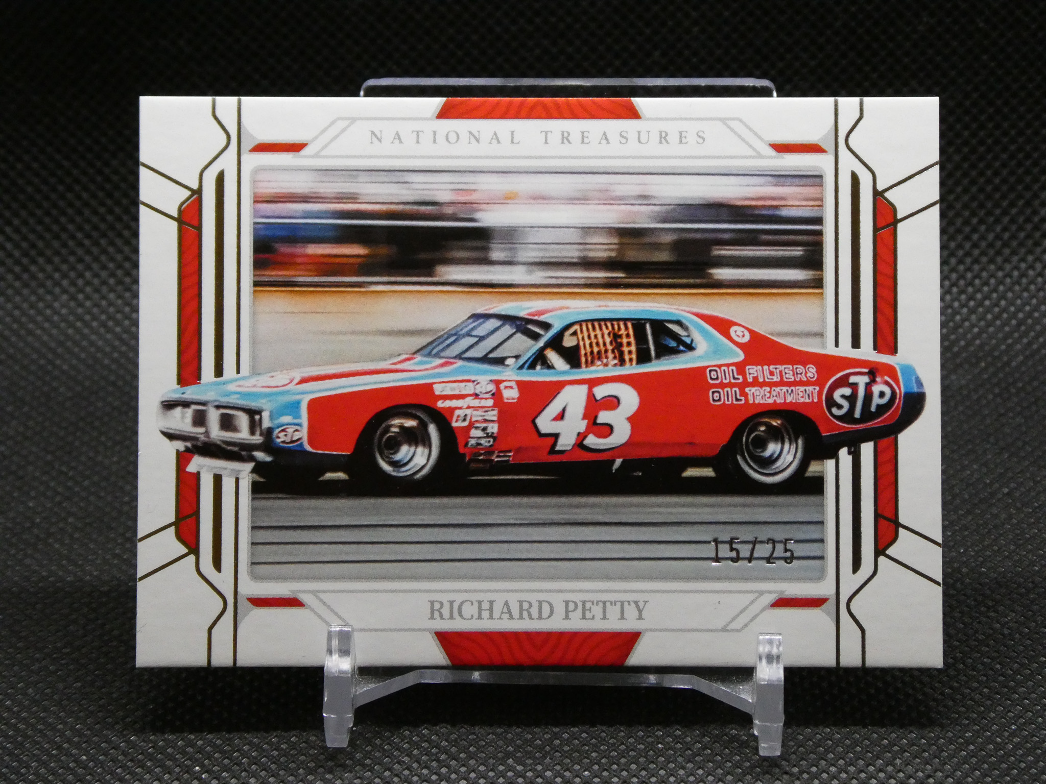 NASCAR race car model packaging showing a red and blue car with the number 43 and STP logos behind a clear window.
