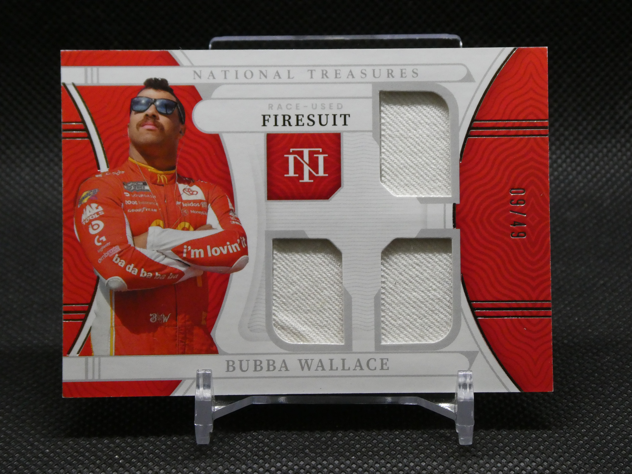 RACE-USED Bubba Wallace firesuit card featuring a photo of Bubba Wallace in red race suit and stitched fabric panels.