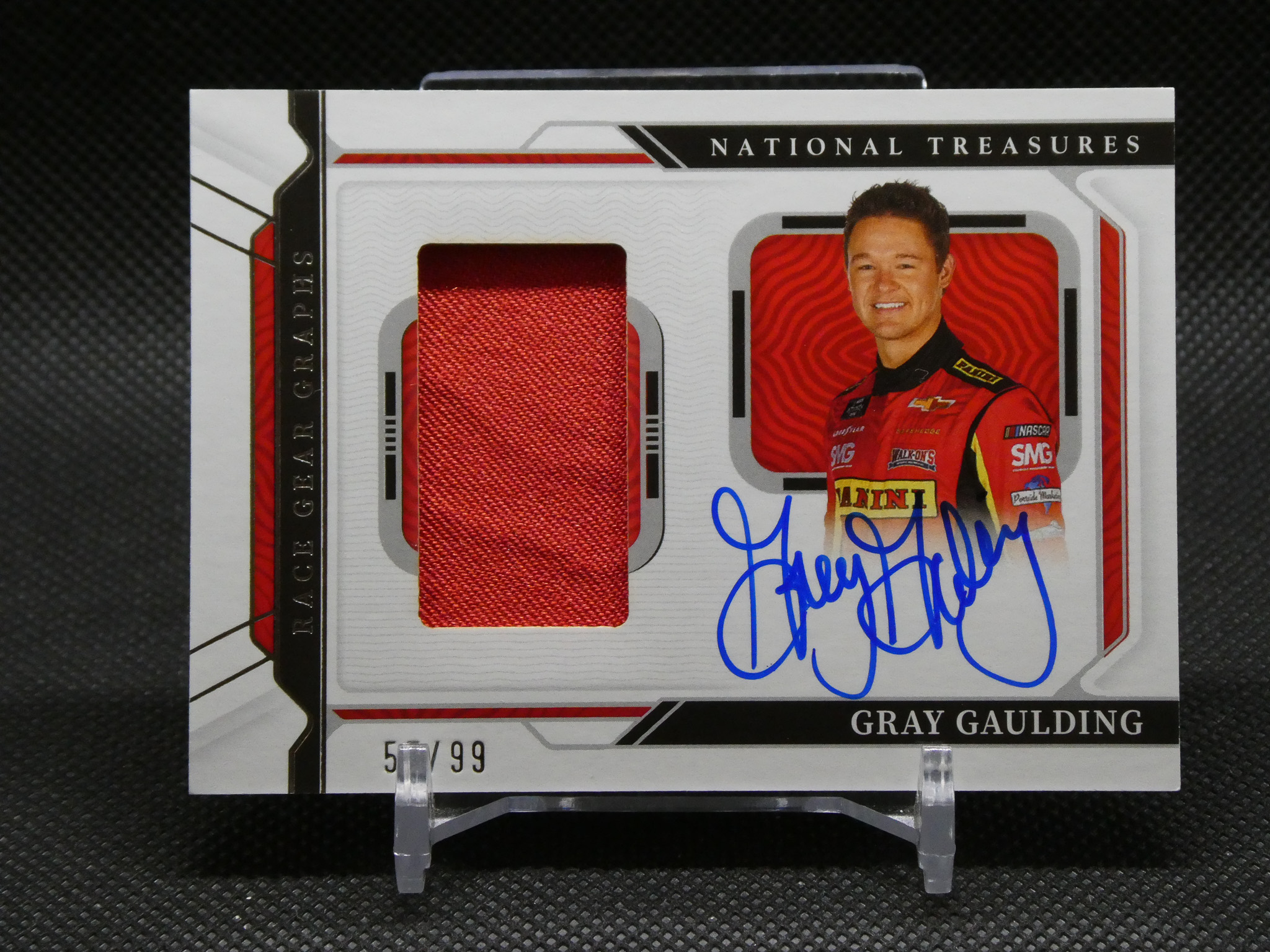 Autographed National Treasures NASCAR trading card with a red fabric swatch and blue signature.