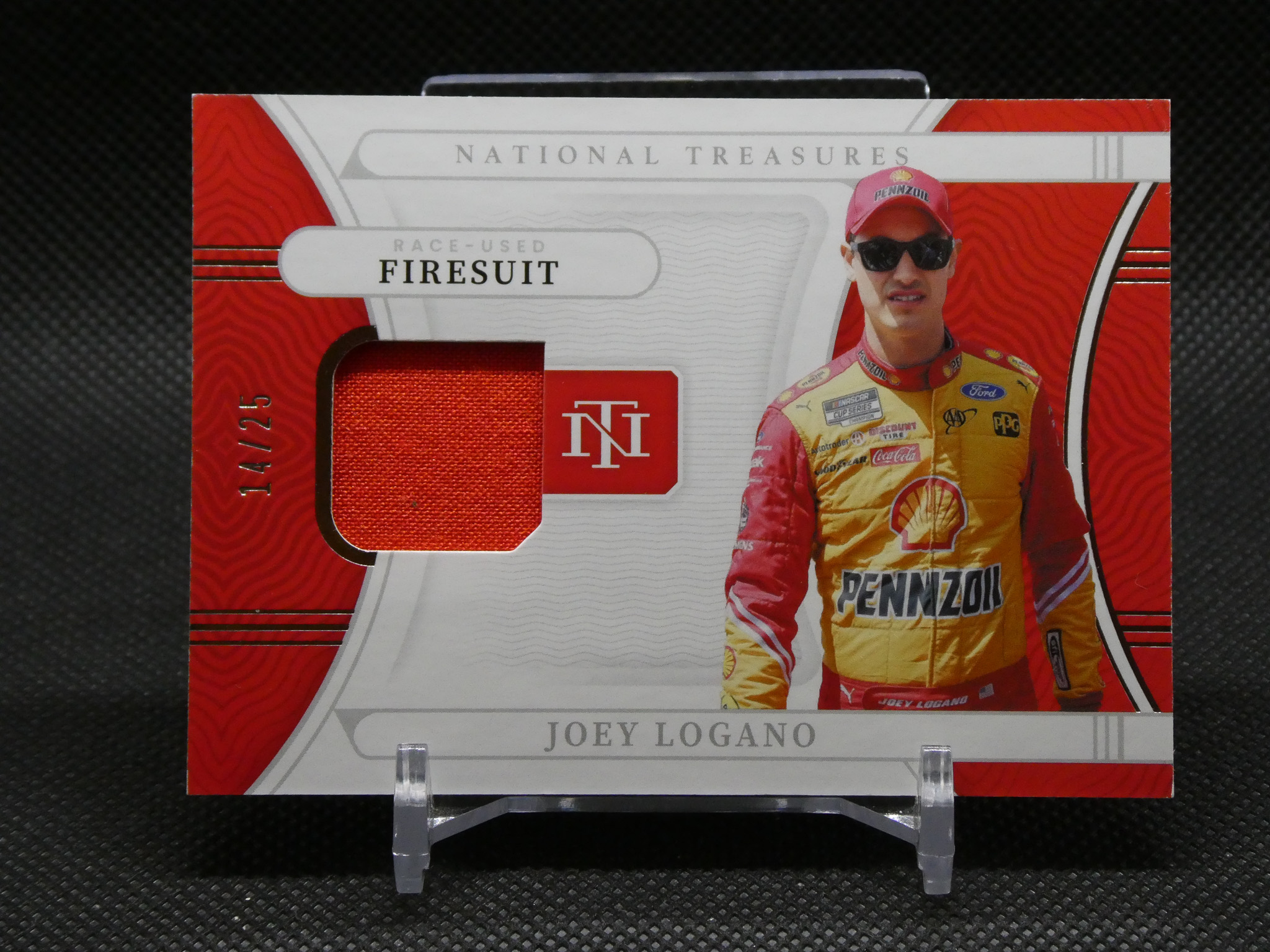 Packaging for a racing memorabilia card showing Joey Logano in a yellow Pennzoil race suit with red accents and 'National Treasures' branding.