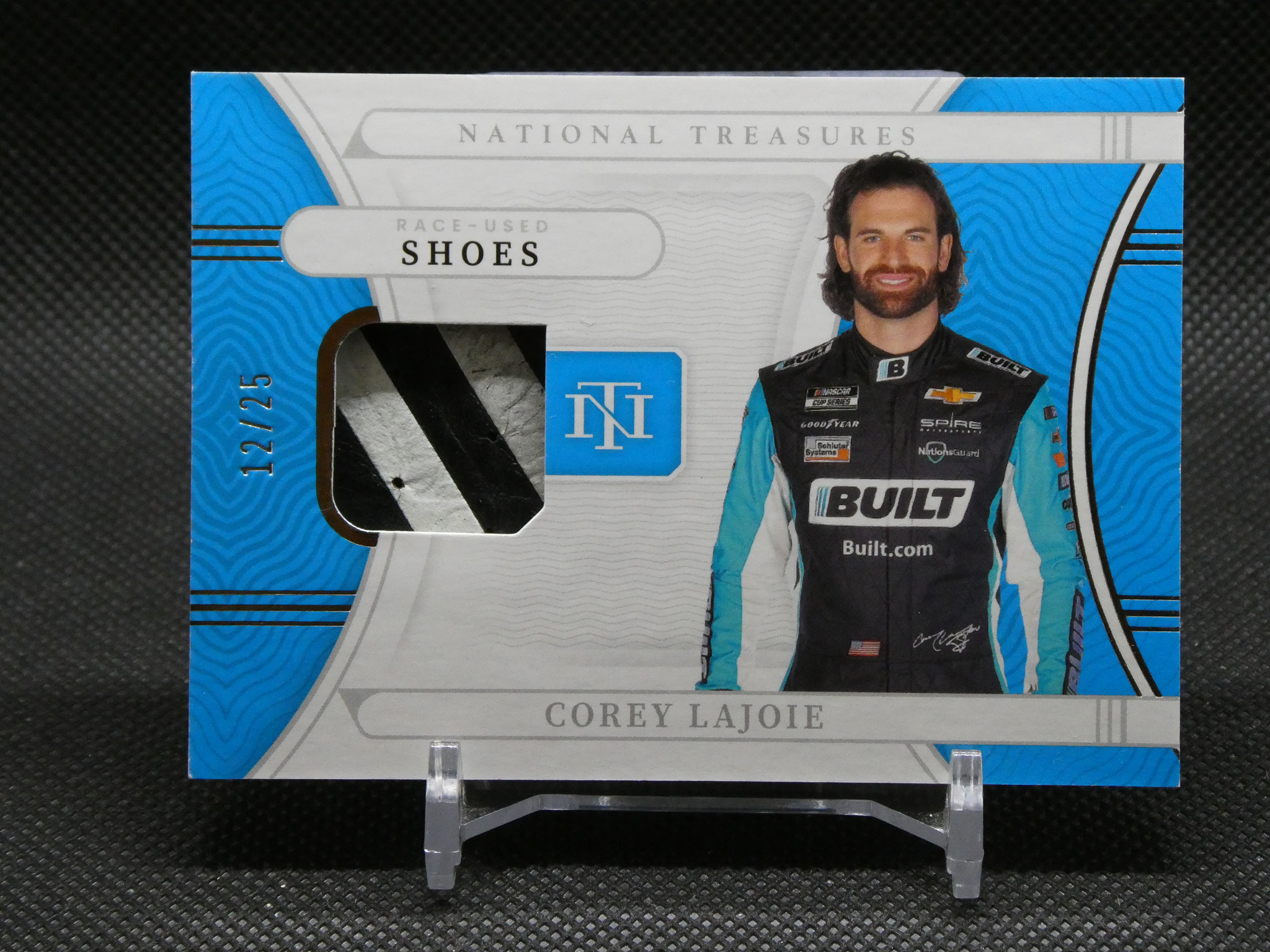 Front of a sealed box featuring NASCAR driver Corey LaJoie in a blue racing suit, with 'National Treasures' branding and his name at the bottom.