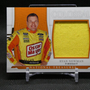 Portrait of NASCAR driver Ryan Newman in a yellow sponsor-laden firesuit, standing beside a textured gold fabric swatch on a display card.