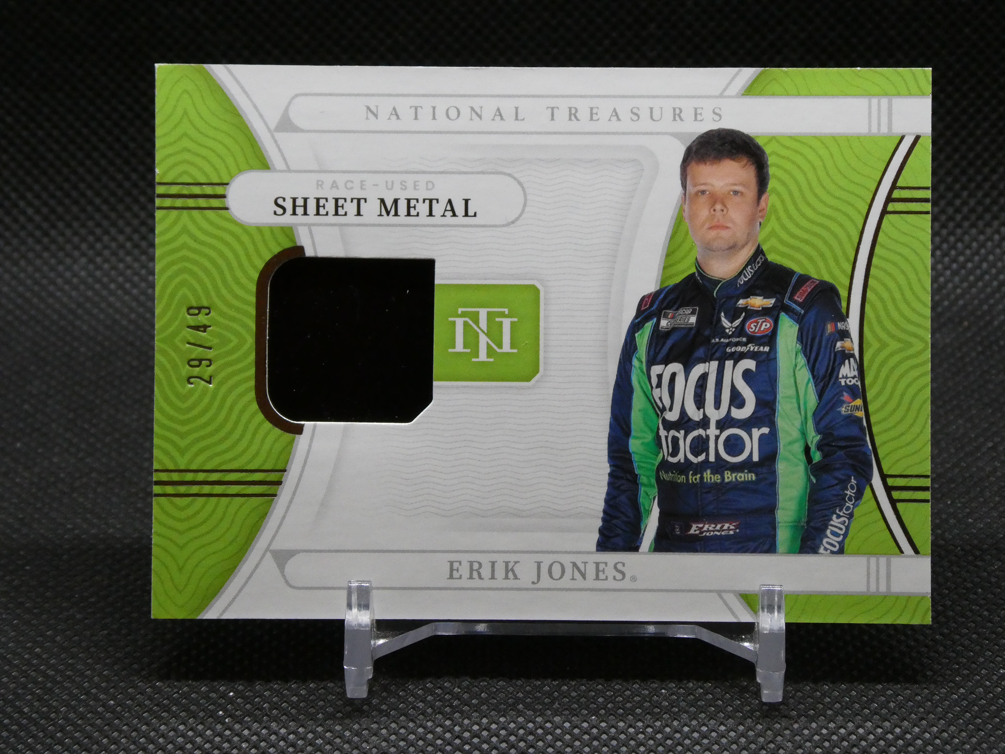 Race-used sheet metal card from National Treasures featuring NASCAR driver Erik Jones and his image on the right side.