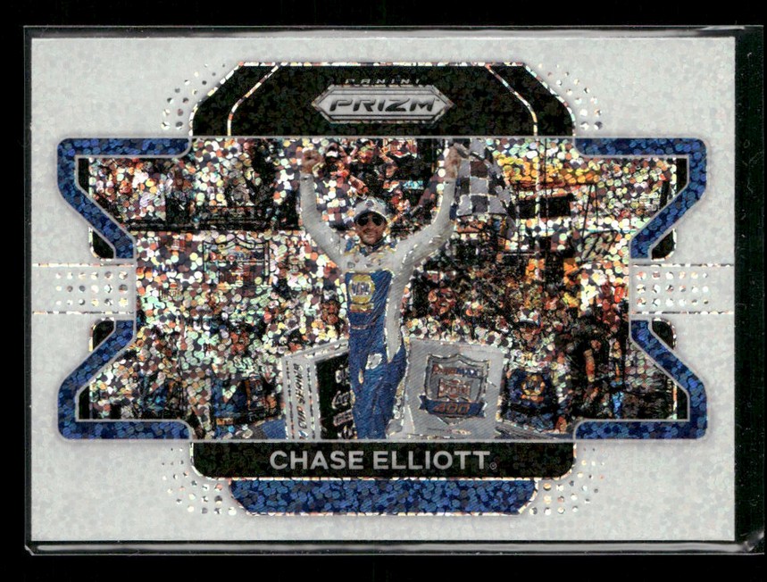 Trading card image of NASCAR driver Chase Elliott celebrating with arms raised on a podium, blue racing suit, crowd behind him, holographic foil design.