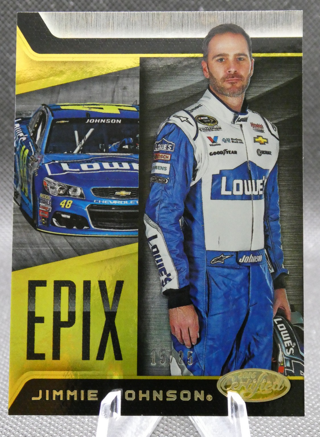 Trading card featuring NASCAR driver Jimmie Johnson in a blue-and-white Lowe's racing suit, with a blue Chevrolet car in the background on the left side of the card.