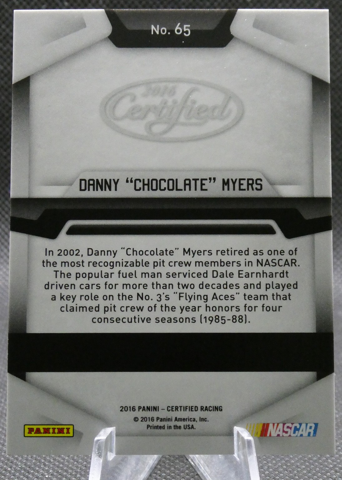 Back of a 2016 Panini NASCAR trading card featuring Danny 'Chocolate' Myers with a bio paragraph and No. 65 at top.