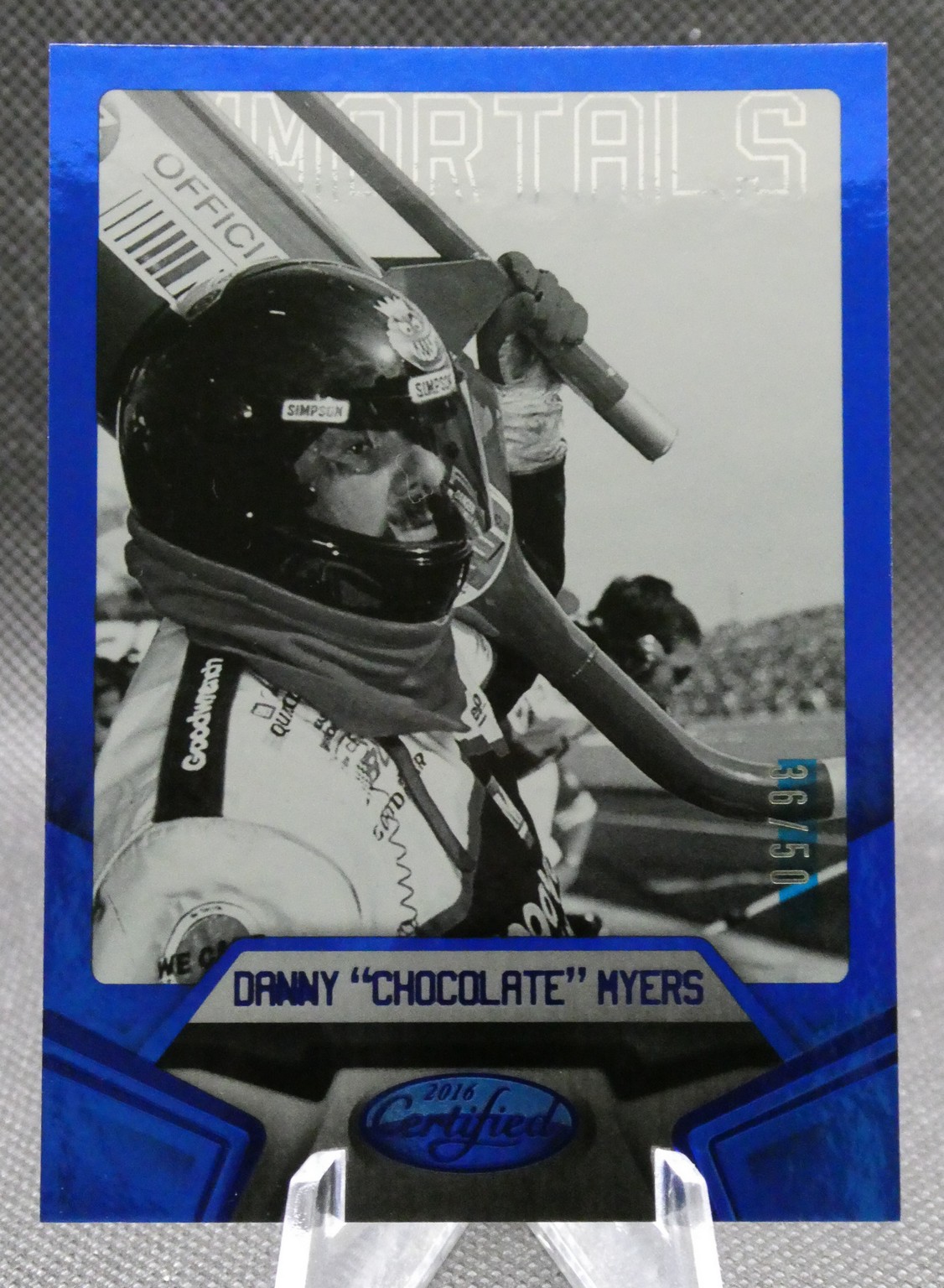 Trading card of race car driver Danny 'Chocolate' Myers in a helmet and racing suit inside a blue frame.