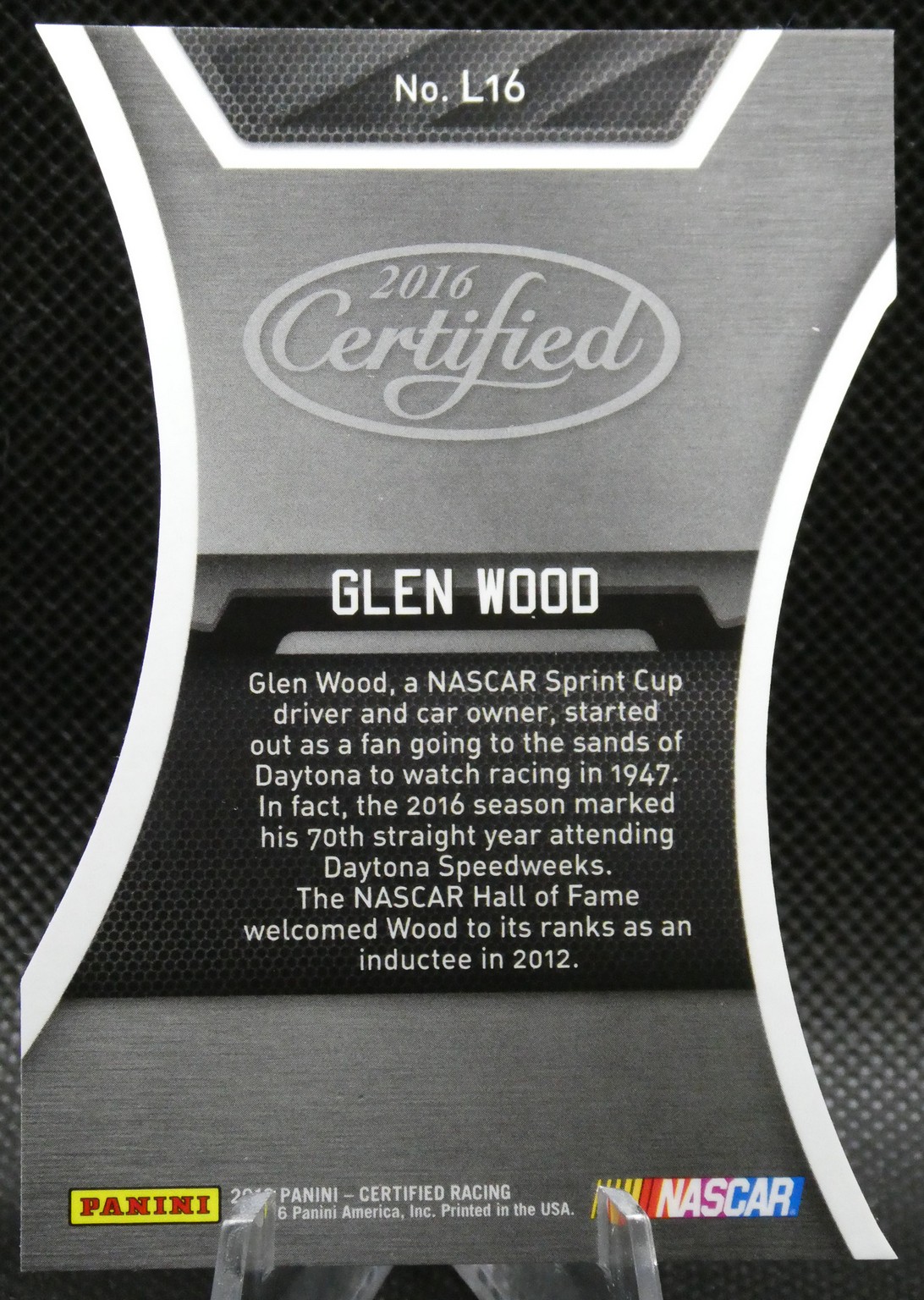 Gray NASCAR card for Glen Wood: features 'No. L16', '2016 Certified', 'GLEN WOOD' and a bio paragraph, with Panini and NASCAR logos at the bottom.