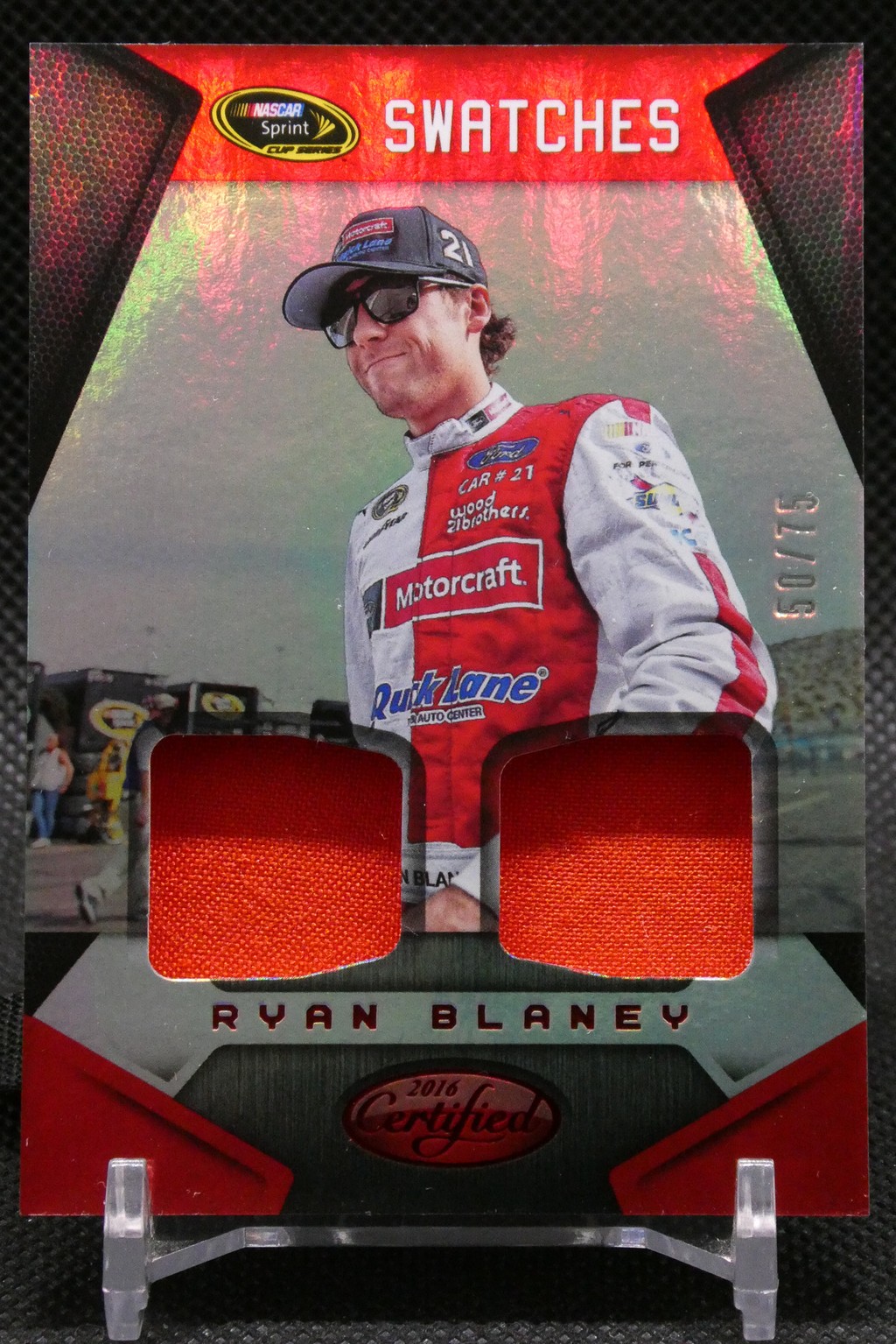 Trading card featuring NASCAR driver Ryan Blaney in a red-and-white racing suit with two red fabric swatches embedded and 'SWATCHES' at the top.
